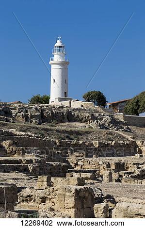 Stock Image - White lighthouse against a blue sky; Paphos, Cyprus. Fotosearch