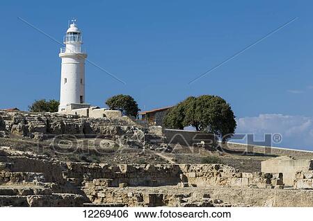 Stock Photograph - White lighthouse against a blue sky; Paphos, Cyprus. Fotosearch