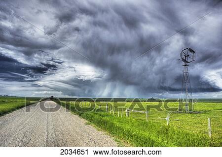 Windmill And Country Road With Storm Clouds Near Carstairs, Alberta View Large Photo Image Stock Image - Windmill And Country Road With Storm Clouds Near Carstairs, Alberta. Fotosearch