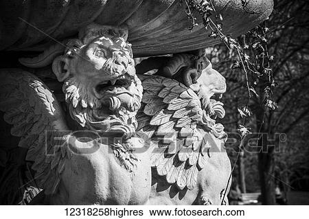 Stock Photograph - Winged lions hold up a beautiful planter of vines and flowers in The Avenue Gardens, Regent's Park; London, England. Fotosearch