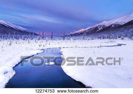 Stock Image - Winter view of first light on the Chugach Mountains from the salmon viewing deck at the Eagle River Nature Center, Southcentral Alaska, HDR. Fotosearch