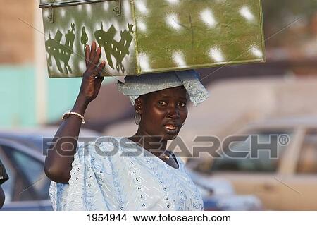 Picture - Woman carrying a trunk on her head in Mopti, Mali. Fotosearch