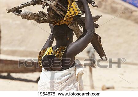 Woman carrying baby on her back with log of wood on head at Niafunke, Mali View Large Photo Image Stock Photography - Woman carrying baby on her back with log of wood on head at Niafunke, Mali. Fotosearch