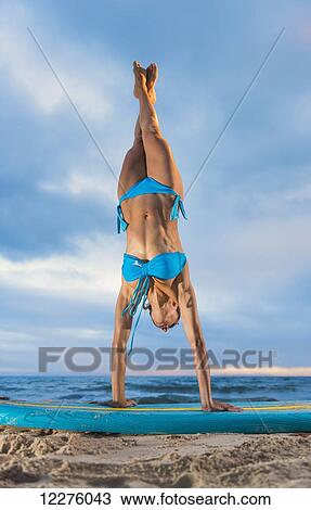 Stock Image - Woman exercising on a surfboard; Tarifa, Cadiz, Andalusia, Spain. Fotosearch