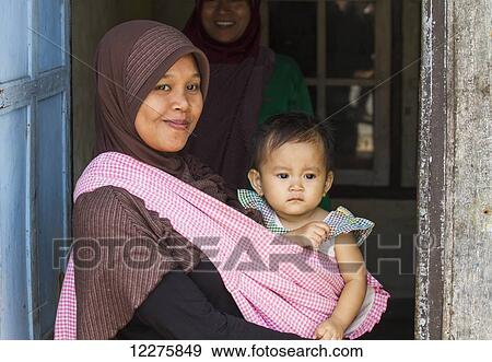 Woman holding a girl, Semparu, Lombok, West Nusa Tenggara, Indonesia View Large Photo Image Stock Photo - Woman holding a girl, Semparu, Lombok, West Nusa Tenggara, Indonesia. Fotosearch