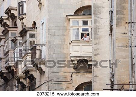 Stock Photography - Woman In An Enclosed Balcony, Valletta, Malta. Fotosearch