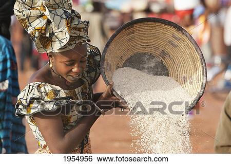 Stock Photograph - Woman sifting couscous in Mopti, Mali. Fotosearch