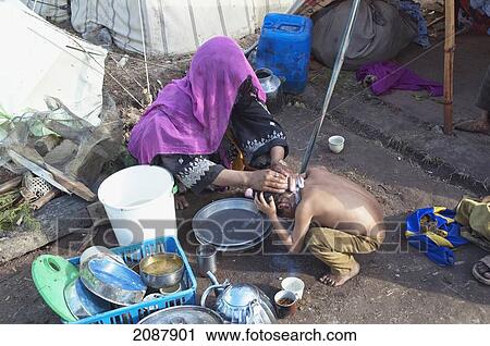 Stock Image - Woman Washing A Boy In A Relief Camp After The 8 October 2005 Earthquake, Muzaffarabad, Azad Kashmir, Pakistan. Fotosearch