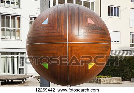 Wooden spherical sculpture in the market square; Gilching, Bayern, Germany View Large Photo Image Stock Image - Wooden spherical sculpture in the market square; Gilching, Bayern, Germany. Fotosearch