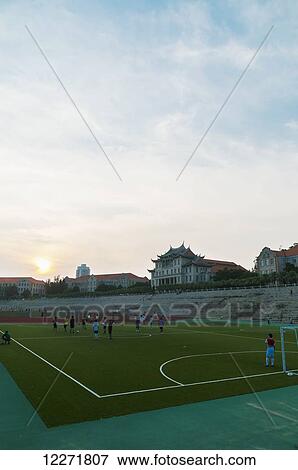 Stock Photo - Xiamen University Stadium at sunset with some students playing sports; Xiamen, Fujian Province, China. Fotosearch