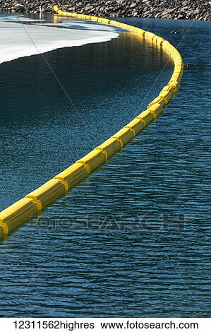 Stock Photograph - Yellow buoy across the water with rocky shoreline and ice on lake, Kananaskis Country, Alberta, Canada;. Fotosearch