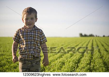 Young boy standing in a farm field in summertime; Saskatchewan, Canada View Large Photo Image Stock Photograph - Young boy standing in a farm field in summertime; Saskatchewan, Canada. Fotosearch