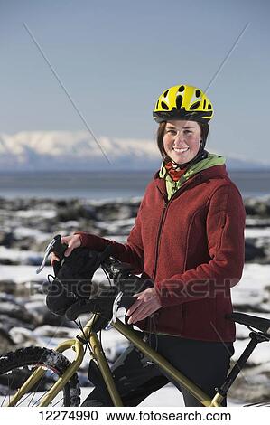 Young woman with her bicycle standing on frozen ice chunks along the Tony Knowles Coastal Trail, Anchorage, Southcentral Alaska View Large Photo Image Stock Image - Young woman with her bicycle standing on frozen ice chunks along the Tony Knowles Coastal Trail, Anchorage, Southcentral Alaska. Fotosearch