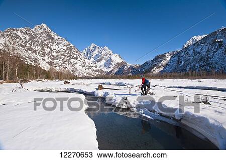 A man snowshoeing in the Eagle River Valley on a sunny winter day with Mount Yukla in the background, Chugach State Park; Alaska, United States of America View Large Photo Image Stock Image - A man snowshoeing in the Eagle River Valley on a sunny winter day with Mount Yukla in the background, Chugach State Park; Alaska, United States of America. Fotosearch