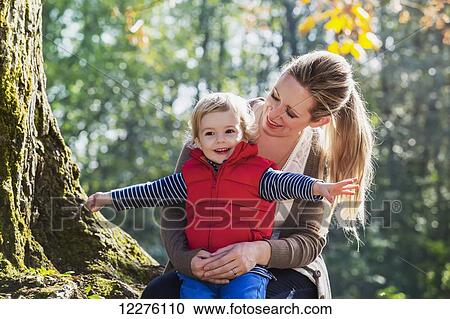 A mother holding her toddler son in a park in autumn; Langley, British Columbia, Canada View Large Photo Image Stock Image - A mother holding her toddler son in a park in autumn; Langley, British Columbia, Canada. Fotosearch