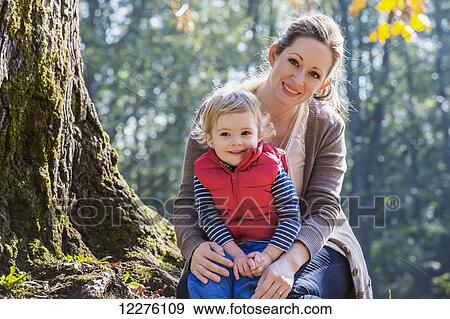 A mother holding her toddler son in a park in autumn; Langley, British Columbia, Canada View Large Photo Image Stock Photo - A mother holding her toddler son in a park in autumn; Langley, British Columbia, Canada. Fotosearch