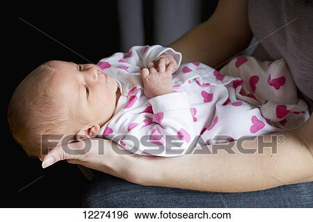 Stock Photograph - A mother holds her newborn baby daughter; Chilliwack, British Columbia, Canada. Fotosearch