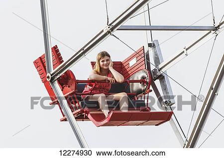 Stock Image - A pre-teen girl waiting patiently for the ferris wheel to load; Edmonton, Alberta, Canada. Fotosearch