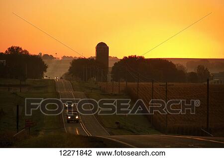 A rolling country road at sunrise passes through agricultural fields and past farmsteads, near Sioux City; Iowa, United States of America View Large Photo Image Stock Image - A rolling country road at sunrise passes through agricultural fields and past farmsteads, near Sioux City; Iowa, United States of America. Fotosearch