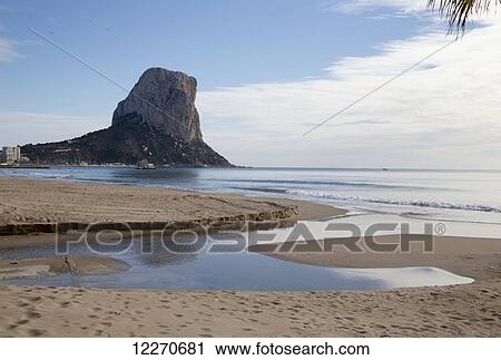 A rugged rocky peak along the coastline with a beach and tide pool in the foreground; Altea, Spain View Large Photo Image Stock Image - A rugged rocky peak along the coastline with a beach and tide pool in the foreground; Altea, Spain. Fotosearch