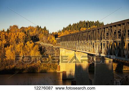 Stock Photo - A truss bridge over a river in autumn; Nipawin, Saskatchewan, Canada. Fotosearch