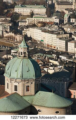 Stock Image - A view from the castle over the city's rooftops with the dome of the cathedral towering above the other buildings; Salzburg, Austria. Fotosearch