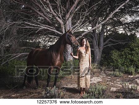 A woman standing with a horse; Tarifa, Cadiz, Andalusia, Spain View Large Photo Image Stock Photograph - A woman standing with a horse; Tarifa, Cadiz, Andalusia, Spain. Fotosearch