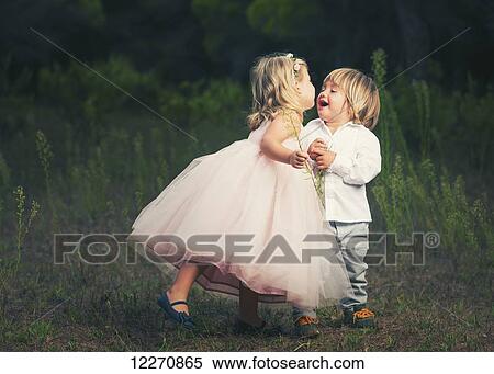 A young girl with a pink princess dress leans in to kiss a young boy; Tarifa, Cadiz, Andalusia, Spain View Large Photo Image Stock Photography - A young girl with a pink princess dress leans in to kiss a young boy; Tarifa, Cadiz, Andalusia, Spain. Fotosearch