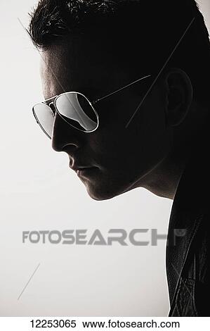 Stock Photography - A young man wearing sunglasses; Edmonton, Alberta, Canada. Fotosearch