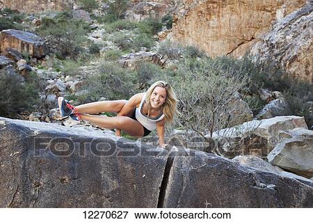 A young woman doing a difficult yoga pose on a large rock in White Tank Mountain range; Arizona, United States of America View Large Photo Image Stock Photo - A young woman doing a difficult yoga pose on a large rock in White Tank Mountain range; Arizona, United States of America. Fotosearch