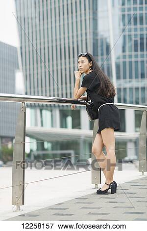Stock Photo - A young woman in the business district; Xiamen, China. Fotosearch