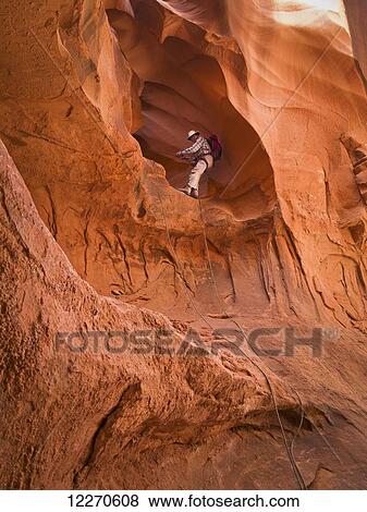 Adventurer exploring a desert slot canyon; Hanksville, Utah, United States of America View Large Photo Image Stock Photo - Adventurer exploring a desert slot canyon; Hanksville, Utah, United States of America. Fotosearch