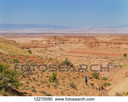 Stock Image - Adventurers exploring a desert slot canyon; Hanksville, Utah, United States of America. Fotosearch