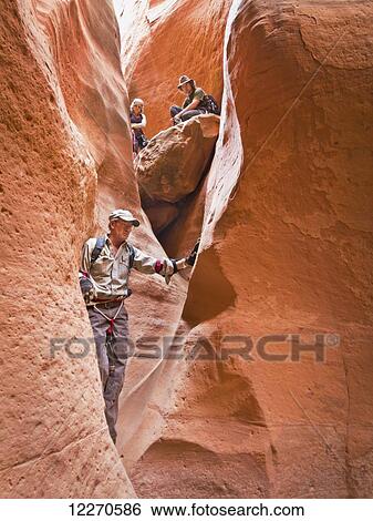 Adventurers exploring a desert slot canyon; Hanksville, Utah, United States of America View Large Photo Image Stock Photograph - Adventurers exploring a desert slot canyon; Hanksville, Utah, United States of America. Fotosearch