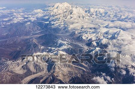 Stock Image - Aerial view of Mount McKinley from the West, lakes and glaciers, low altitude clouds in the distance, Denali National Park; Alaska, United States of America. Fotosearch