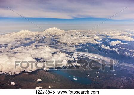 Stock Photography - Aerial view of Mount McKinley from the West, lakes and glaciers, low altitude clouds in the distance, Denali National Park; Alaska, United States of America. Fotosearch