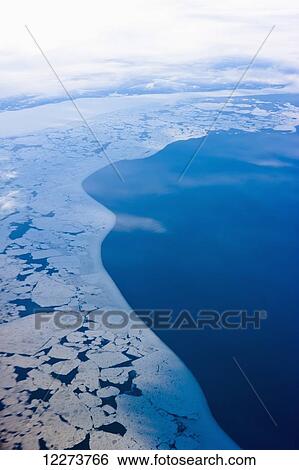 Stock Photograph - Aerial view of sea ice and open ocean in winter; Nome, Alaska, United States of America. Fotosearch