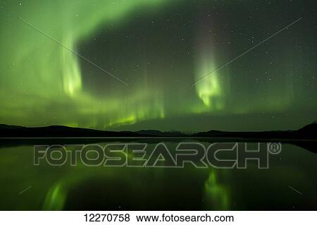Stock Photo - Aurora Borealis (Northern Lights) reflected in 50 Mile Lake along the Denali Highway, Southcentral Alaska; Alaska, United States of America. Fotosearch