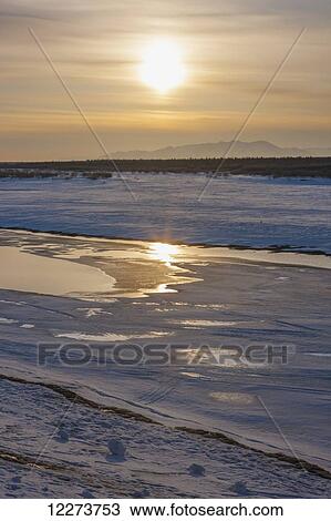 Stock Image - Bank of frozen Noatak River during sunset in winter; Noatak, Alaska, United States of America. Fotosearch