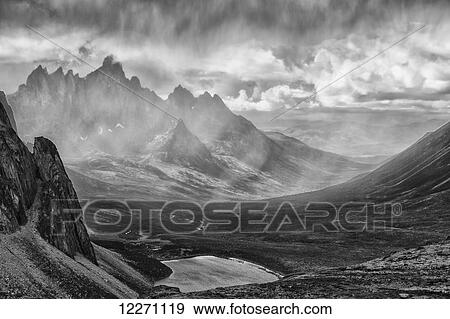 Stock Photo - Black and White image of a rain storm over the Tombstone Valley in Tombstone Territorial Park, with Tombstone Mountain shrouded in the rain in the distance; Yukon, Canada. Fotosearch