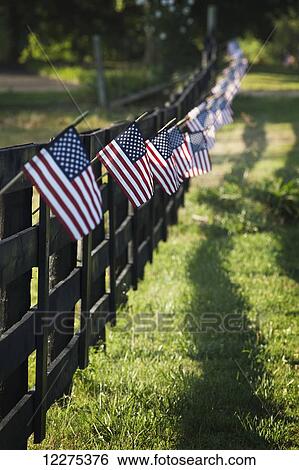 Black wooden fence trailing off with small US flags hanging from each post; United States of America View Large Photo Image Stock Photograph - Black wooden fence trailing off with small US flags hanging from each post; United States of America. Fotosearch