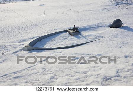 Stock Image - Boat with an outboard engine buried in snow; Noatak, Alaska, United States of America. Fotosearch