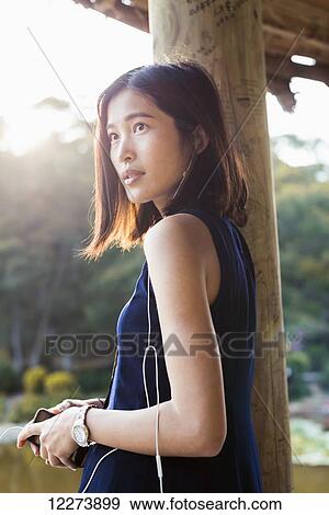 Stock Photo - Chinese girl listening to music; Xiamen, Fujian province, China. Fotosearch