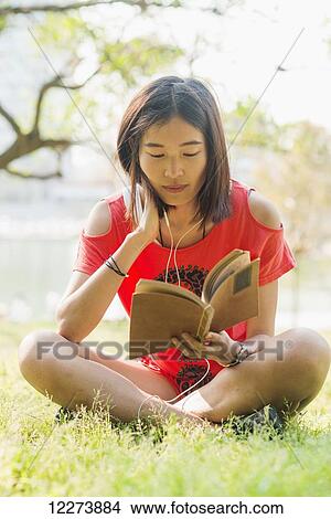 Chinese girl reading a book and listening to music; Xiamen, Fujian Province, China View Large Photo Image Picture - Chinese girl reading a book and listening to music; Xiamen, Fujian Province, China. Fotosearch