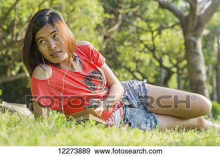 Chinese girl smiling and listening to music; Xiamen, Fujian Province, China View Large Photo Image Stock Photo - Chinese girl smiling and listening to music; Xiamen, Fujian Province, China. Fotosearch