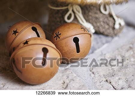 Stock Photo - Christmas bell decorations on stone fireplace; Ontario, Canada. Fotosearch