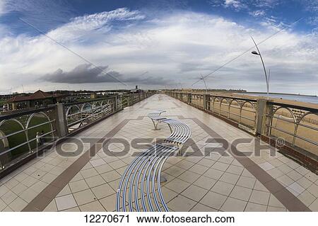Stock Image - Curved bench on the promenade along the beach and waterfront; South Shields, England. Fotosearch