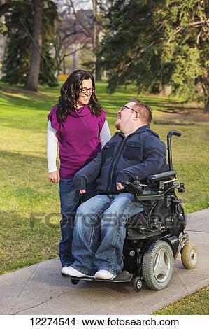 Disabled husband talking with his wife while walking in a park in autumn; Edmonton, Alberta, Canada View Large Photo Image Picture - Disabled husband talking with his wife while walking in a park in autumn; Edmonton, Alberta, Canada. Fotosearch