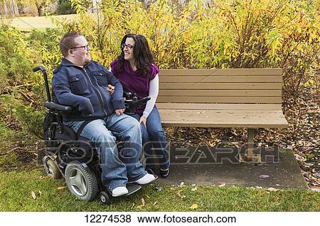Disabled husband talking with his wife on a park bench in autumn; Edmonton, Alberta, Canada View Large Photo Image Stock Photo - Disabled husband talking with his wife on a park bench in autumn; Edmonton, Alberta, Canada. Fotosearch