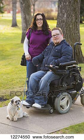 Disabled husband with his wife and their pet dog posing for a family portrait in a park in autumn; Edmonton, Alberta, Canada View Large Photo Image Stock Image - Disabled husband with his wife and their pet dog posing for a family portrait in a park in autumn; Edmonton, Alberta, Canada. Fotosearch